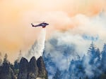 A helicopter drops water to cool hot spots at Oregon's Microwave Tower Fire in this undated, supplied photo.