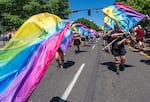 Members of the Rainbow City Color Guard wave their flags around as they march.