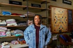 Nikki High transformed her bookstore Octavia's Bookshelf, into a mutual aid hub for Altadena residents affected by the Eaton Fire. High, on January 21, 2025, poses in front of a Scrabble board with a message for developers.