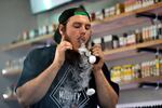 In this Tuesday, Sept. 3, 2019, photo, Devin Lambert, the manager at Good Guys Vape Shop, exhales vapor while using an e-cigarette in Biddeford, Maine.