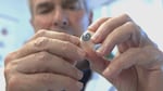 Ocularist Fred Harwin holds a prosthetic eye he's hand-painted for a patient.