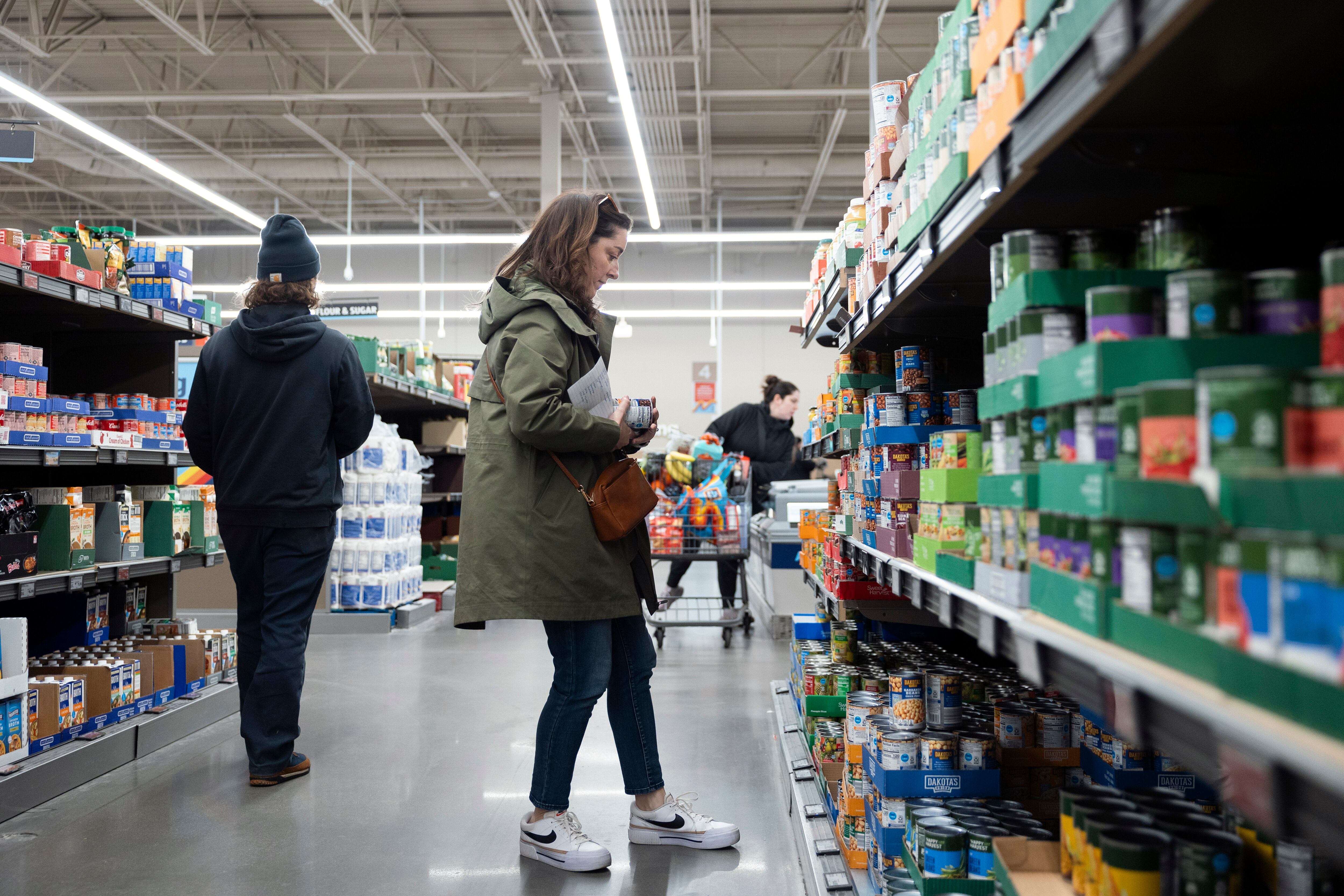 Negro-Henderson looks over canned goods while grocery shopping.
