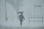 A person holds an umbrella as they walk during a winter storm, Monday, Jan. 6, 2025, in Cincinnati.