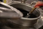 Brewer Zane Tarabochia-Martin rinsing the mash tun while brewing a batch of Worthy Brewing's Northwest IPA in Bend, Ore., Sept. 20, 2022.