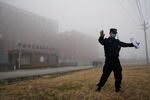 A security official moves journalists away from the Wuhan Institute of Virology after a World Health Organization team arrived for a field visit in Wuhan in China's Hubei province on Wednesday, Feb. 3, 2021. The WHO team is investigating the origins of the coronavirus pandemic has visited two disease control centers in the province.