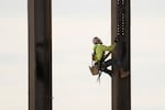 An ironworker scales a column during construction of a municipal building in Norristown, Pa. on Feb. 15, 2023.