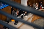 Portland Mayor Keith Wilson, center left, looks to his computer.