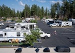 A child bikes around more than a dozen RVs and trailer homes parked at Sisters High School, which is serving as an evacuation shelter for those impacted by the Akawa Butte Fire.