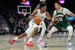 Portland Trail Blazers guard Scoot Henderson (00) tries to get past Milwaukee Bucks guard Ryan Rollins (13) during the second half of an NBA basketball game Wednesday, March 25, 2026, in Portland, Ore.