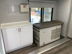 Two small exam rooms inside the mobile clinic include examination tables and medical equipment.