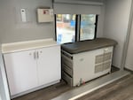 Two small exam rooms inside the mobile clinic include examination tables and medical equipment.