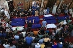 Sun., Oct. 8: People gather at a mosque to pray over the bodies of the Abu Quta family and their neighbours, killed in Israeli strikes on the Palestinian city of Rafah in the southern Gaza Strip.