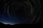 A multiple exposure picture taken in the early hours of August 11, 2013 shows a Perseids meteor shower in the sky on the mountains of the Sierra Norte de Madrid.