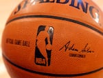 An NBA logo is seen on an official game ball before a game, Feb. 1, 2014, in New York. The NBA said Wednesday that it is not accepting Warner Bros. Discovery's $1.8 billion per year offer to continue its longtime relationship with the league and therefore has entered into a deal with Amazon Prime Video.