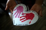 A Oaxacan woman holds artwork created by her UW-born daughter, at her Mount Vernon apartment on Thursday, March 5, 2026.