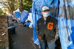 After the City of Portland cleared an encampment of 70-100 people experiencing homelessness in Laurelhurst Park last month, many have returned. Tyler Hardy, one of those who have returned, stands outside his shelter, Dec. 7, 2020.