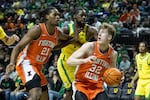 Illinois guard Kasparas Jakucionis (32) looks for a pass with forward Morez Johnson Jr. (21) during the second half of an NCAA college basketball game in Eugene, Ore., Thursday, Jan. 2, 2025.