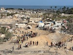 Dust and rubble cover tents and vehicles at the site of the attack.