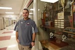 Camas High School Athletic Director Rory Oster in front of one of several trophy cases honoring the Papermakers.