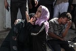 Relatives of Palestinians, killed by Israeli forces during airstrike clashes, mourn after they were taken to the morgue of Shifa Hospital in Gaza City, Gaza.
