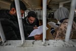 Syrians inspect documents in the infamous Saydnaya prison, just north of Damascus, on Monday. Crowds are entering the prison, known as the "human slaughterhouse," following the ouster of Bashar al-Assad's and the release of thousands of prisoners who were held by the regime.