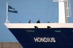Passengers stand on the deck of the hantavirus-stricken cruise ship MV Hondius after it arrives at the port of Granadilla in Tenerife, Canary Islands, Spain, Sunday, May 10, 2026. 