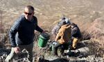 People stand in a line holding buckets