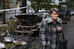 An elderly woman reacts next to the house destroyed by a Russian strike in Zaporizhzhia, Ukraine, Sunday, Oct. 5, 2025.