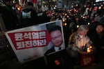 People hold candles during a candlelight vigil against South Korean President Yoon Suk Yeol in Seoul, South Korea, Wednesday, Dec. 4, 2024. (AP Photo/Lee Jin-man)