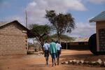 Paris (right) walks to class with fellow morans Saidimu Lolokile (left) and Loshaki Lekiliyo (center). Soon after Paris started at the elementary school, he convinced the others to join him. Now the three boys are inseparable.