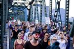 Hundreds of people overtake the Hawthorne Bridge chanting "Whose bridge? Our bridge!" in a march for solidarity with the community of Charlottesville. Traffic was stopped behind them.