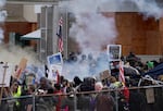 FILE - Tear gas is deployed as hundreds of people protest outside of the Immigration and Customs Enforcement building in Portland, Ore., Jan. 31, 2026. 