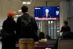 People watch a TV screen showing South Korean President Yoon Suk Yeol's televised briefing at a bus terminal in Seoul, South Korea, Tuesday, Dec. 3, 2024.