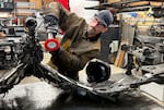 Metalsmith artist Travis Pond buffs a part of a metal sculpture in progress. The finished product will resemble a heron in flight.