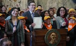 Gov. Bob Ferguson appears with supporters of the bill after signing the legislation into law on March 9, 2026. House Bill 2355 establishes labor rights for nannies, gardeners and other domestic workers.