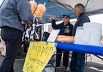 From left, Longview Pioneer Lion’s Club wife and husband Penny Piper, center, and Bob Piper collect donations for families impacted by the Nippon Dynawave Packaging Co. chemical disaster during their weekly kettle corn fundraiser in Longview, Wash., on May 29, 2026.