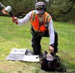 Assistant Professor Ezra Che at OSU’s School of Civil and Construction Engineering hammers a target into the grass at Silver Falls State Park for a drone.