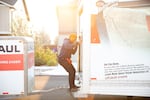 Andrés Portela III pulls down the door on the back of a rented U-Haul truck in Bend, Ore., on Aug. 28, 2025. Portela moved his family back to Arizona before resigning from his city job.