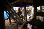 Jose Ortiz pauses, Monday, Dec. 7, 2020, at the ladder to the residence he built in the homeless encampment known as the Jungle in Ithaca, N.Y. When Ortiz tested positive for COVID-19 last month, he was able to isolate at his elaborately crafted shelter, which includes a “treehouse” about waist-high with a wood stove pipe and a tree protruding from the tarp-covered top.