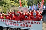 Akira Banzai, (C) chief of Japan's farmers association and their members gesture as they protest against the Trans-Pacific Partnership (TPP) free trade talks at a rally in Tokyo on March 12, 2013, when Prime Minister Shinzo Abe was expected to announce he would join TPP negotiations that week.