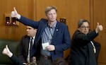 Rep. Jason Kropf, D-Bend, left, and Rep. Tawna Sanchez, D-North and Northeast Portland, right, signify their vote as the Oregon House of Representatives convene at the Oregon State Capitol in Salem, March 20, 2023.