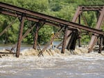 Floodwaters rush over a collapsed railroad bridge over the Big Sioux River near North Sioux City, S.D., on Monday.