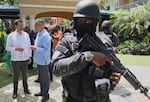 Security guards stand watch as Haiti's Prime Minister Alix Didier Fils-Aime, center, talks with the Mexico's Charge d'Affaires Jesus Cisneros after attending an event marking one year since the start of the Multinational Security Support Mission in Port-au-Prince, Haiti on Thursday.