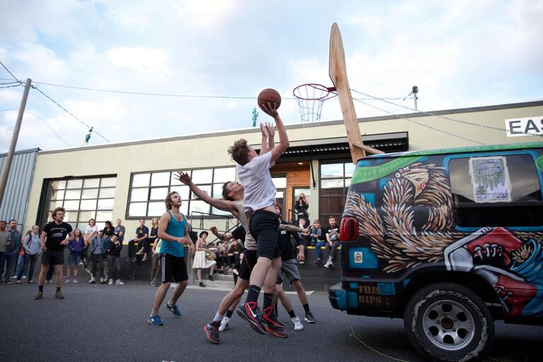A group of men play Rigsketball, an annual basketball tournament played on a hoop bolted to the back the touring van of Portland-based band And And And. Bim Ditson, the drummer of And And And and former Portland mayoral candidate, created Rigsketball.