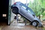 TOPSHOT - A resident walks next to a car raised on a mud-covered street in a flooded area in Picanya, near Valencia, eastern Spain, on October 30, 2024. Floods triggered by torrential rain in Spain's eastern Valencia region have killed 51 people, emergency services said on October 30. (Photo by Jose Jordan / AFP) (Photo by JOSE JORDAN/AFP via Getty Images)