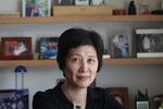 Zha Jianying, a famous Chinese writer, poses for a photo in front of shelves holding photos at her home in Beijing.