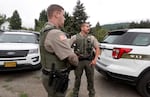 Douglas County Sheriff's Deputy Ryan Gomez, right, stands outside his cruiser while responding to a call in Glendale, Ore. Gomez is a field training officer and said he has helped arrest people after Oregon's recriminalized drug laws went into effect Sept. 1.