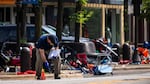 Members of the FBI's Evidence Response Team Unit investigate Tuesday in downtown Highland Park, Ill., the day after a deadly mass shooting. Police say the gunman who attacked an Independence Day parade in suburban Chicago fired more than 70 rounds with an AR-15-style gun.