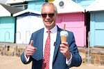 Britain's Reform Party leader Nigel Farage enjoys an ice-cream after casting his vote at a polling station in Walton on the Naze, England, Thursday, May 7, 2026.