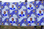 Supporters of the Cameroon People's Democratic Movement (CPDM) hold the new campaign fabric bearing the image of Cameroon's President and presidential candidate Paul Biya.